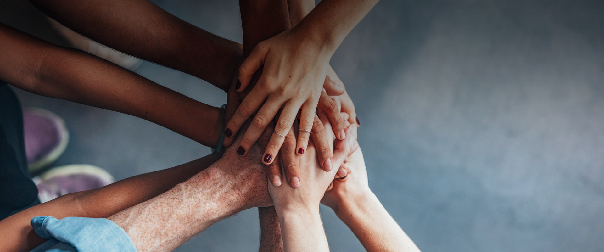 Geste Zusammenhalt – viele Hände berühren einander