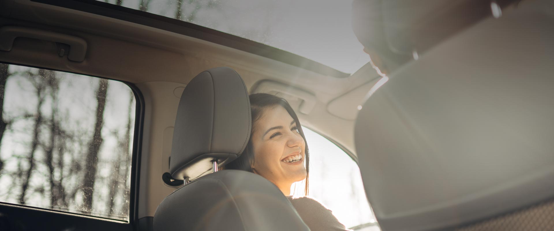 Lächelnde Frau sitzt im Auto